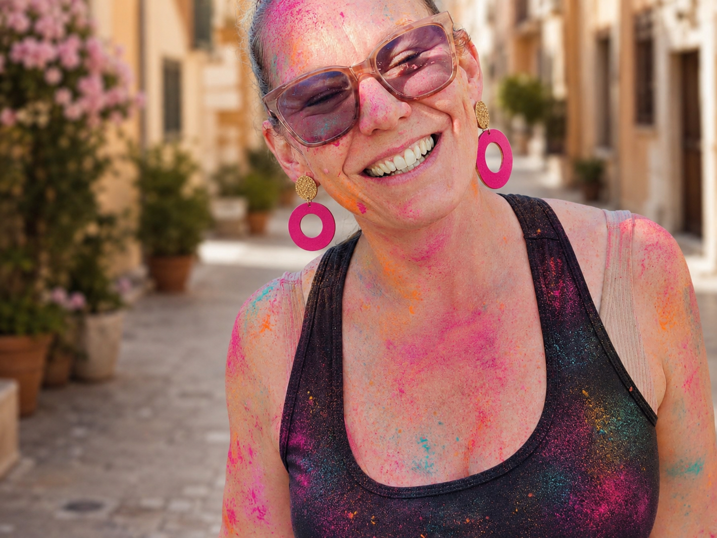 Femme portant des boucles d’oreilles fuchsia LIBRES.