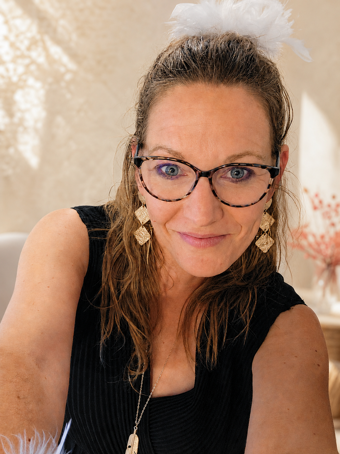Femme portant des boucles d’oreilles dorées LIBRES.