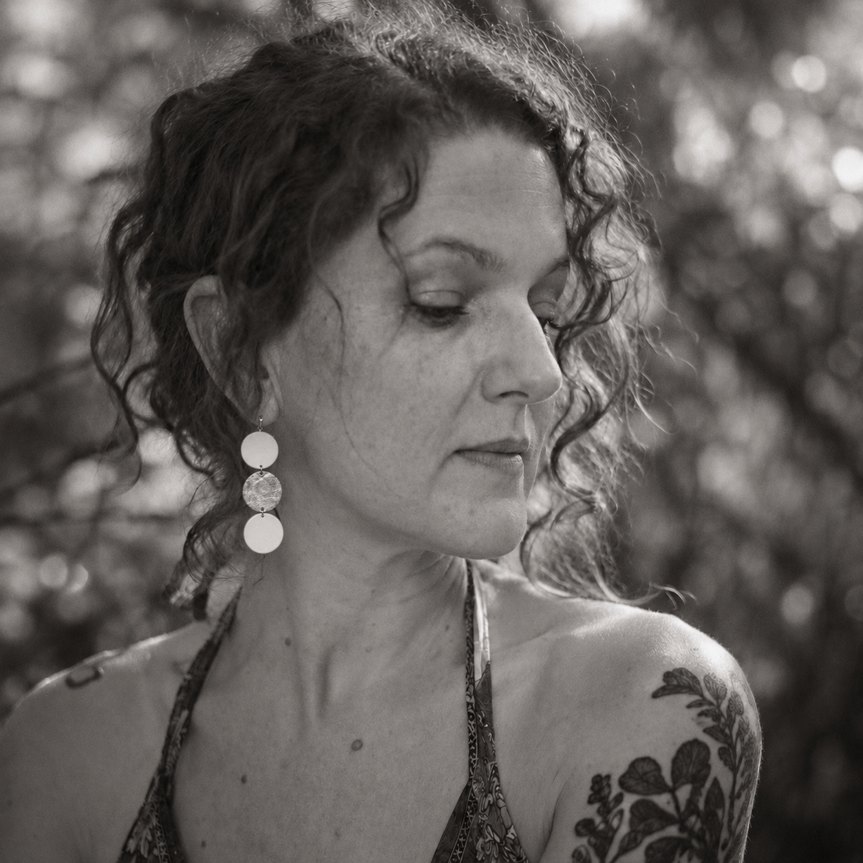 Portrait en noir et blanc avec des boucles d’oreilles LIBRES.